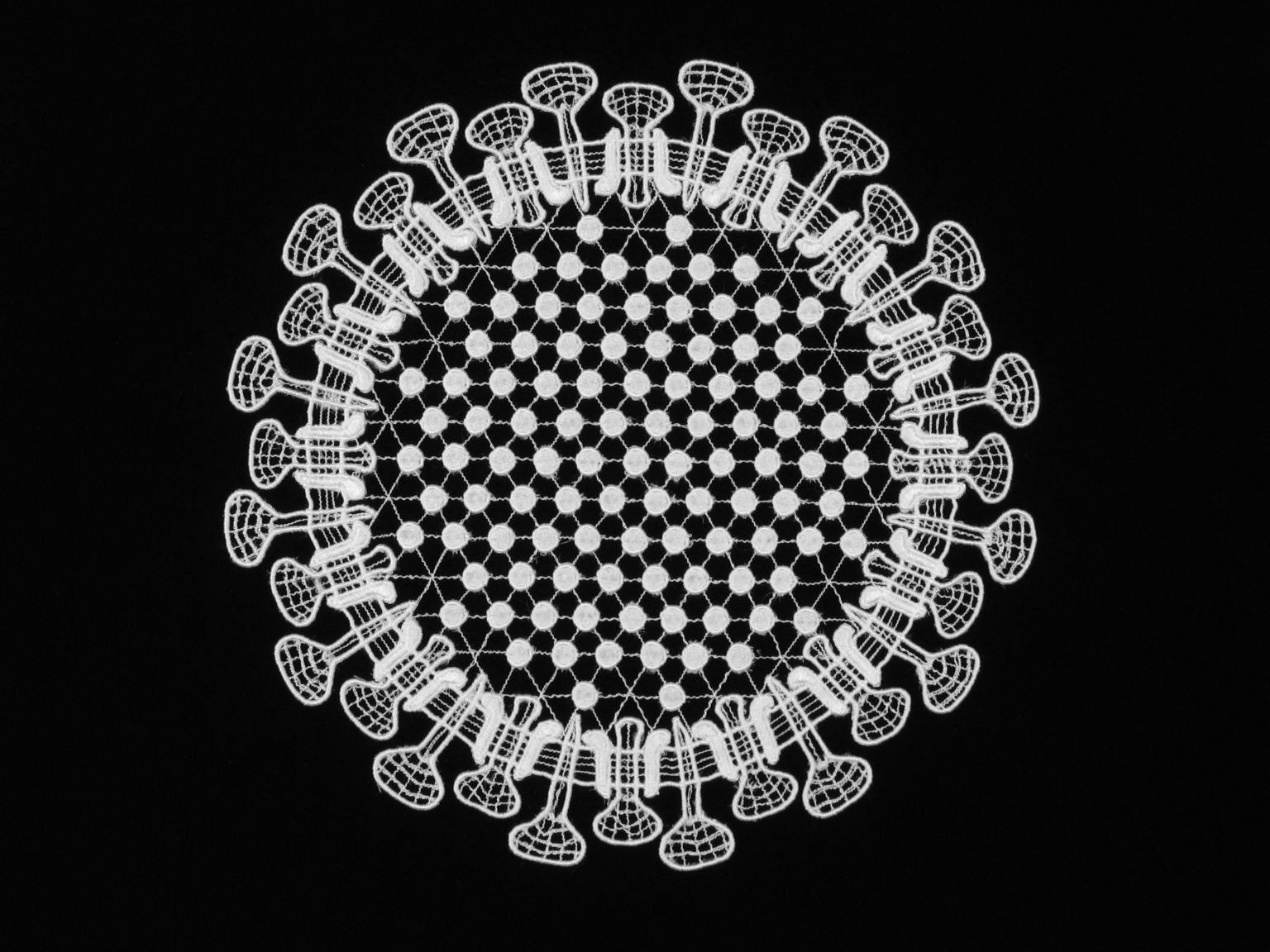 black image of a black background with white crocheted circle design