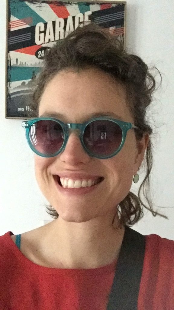 portrait of young woman with blue sunglasses and red shirt