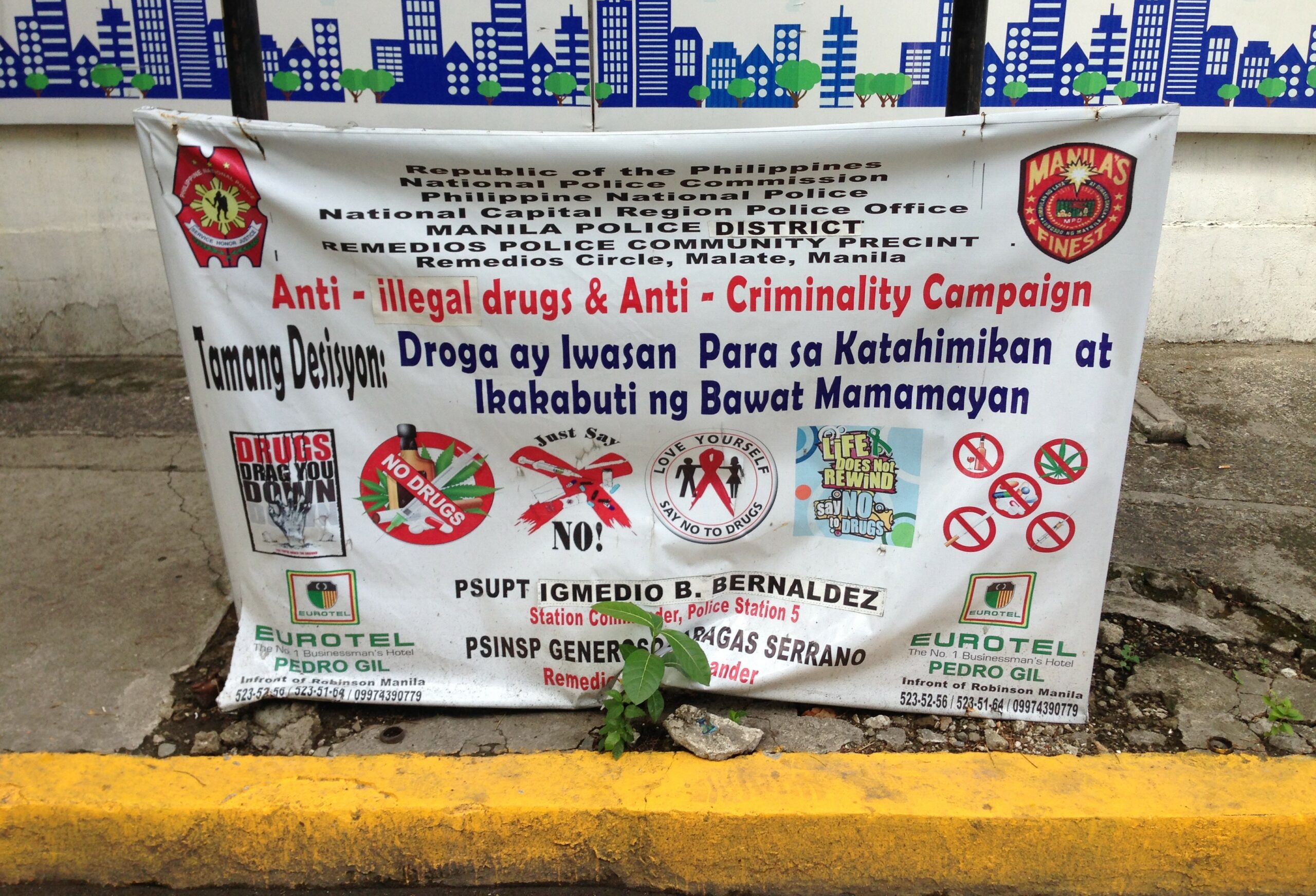 a sign in the street that reads "anti-illegal drugs & anti-criminality campaign"