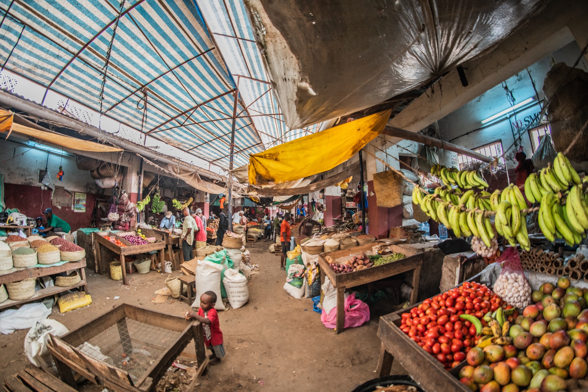 photo of a fruit market, with fruit and spices for sale in tents