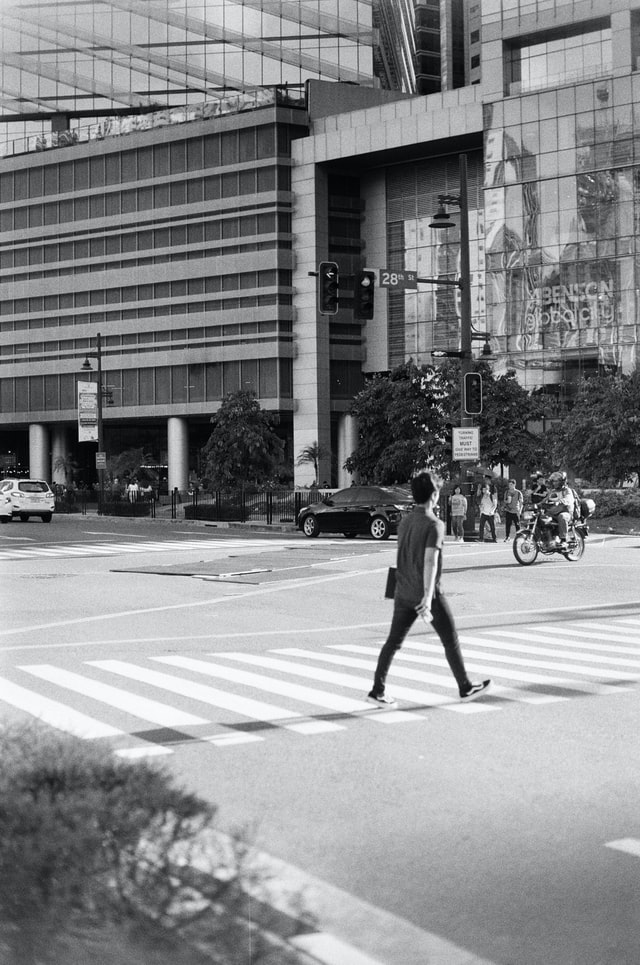 photo of a city street, a person is crossing the road