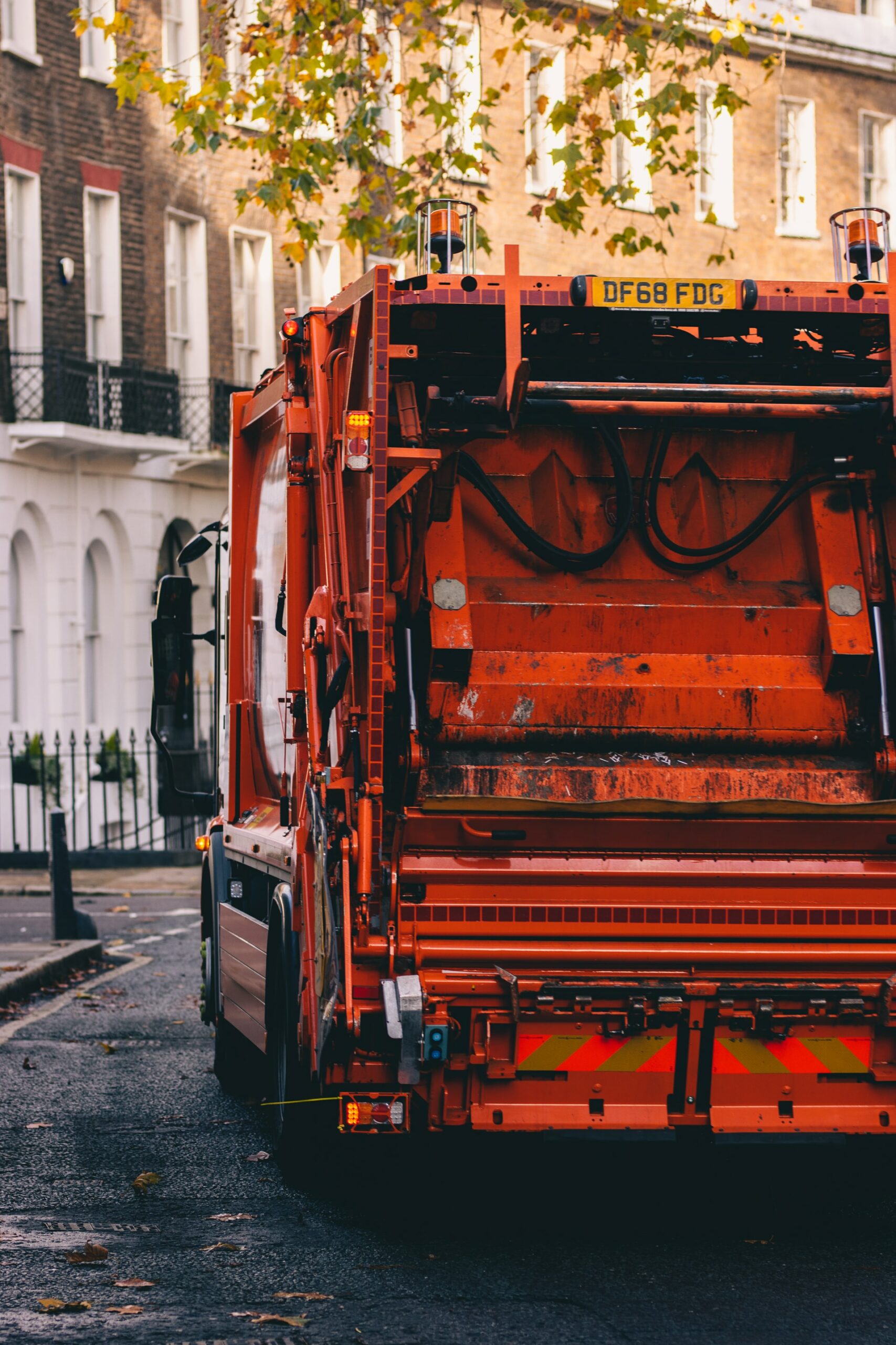 photograph of an orange rubbish collection truck